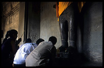 Praying before a Buddha statue inside Angkor Wat. Siem Riep, Angkor, Cambodia