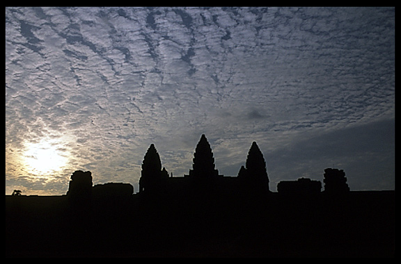 Silhouettes of the towers of Angkor Wat at sunset.