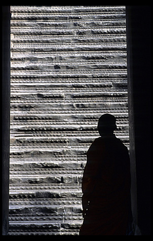 Silhouette of a monk inside Angkor Wat.