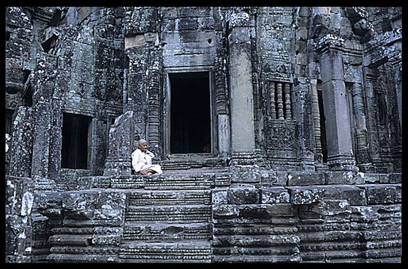A Buddhist nun is resting inside the Bayon.