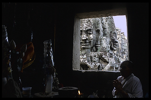 A Buddhist nun is praying inside one of Angkor Thom's many gothic towers in the Bayon.