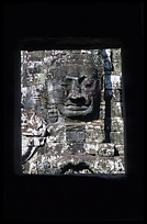 One of the smiling faces in the Bayons seen through a window. Siem Riep, Angkor, Cambodia