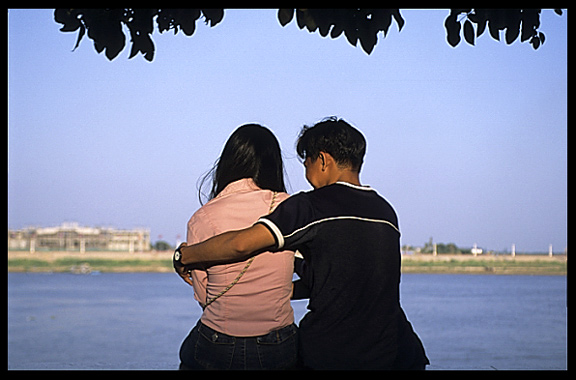 A young Cambodia couple is enjoying the view of the Mekong at Phnom Penh's riverfront.