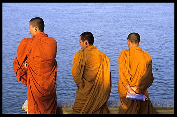 Three monks are enjoying the view of the Mekong at Phnom Penh's riverfront.