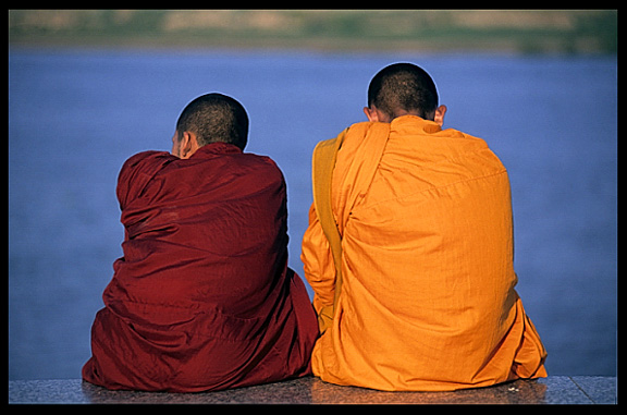 Buddhist monks are enjoying the view of the Mekong at Phnom Penh's riverfront.