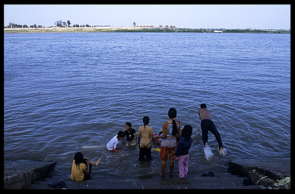 Cambodian children enjoying a fresh dive into the Mekong at Phnom Penh's riverfront.