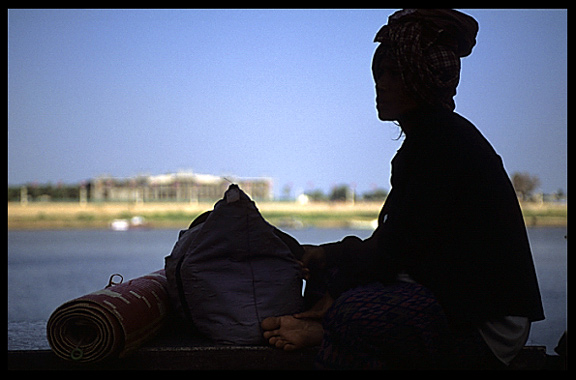 Silhouette of a Cambodian woman at Phnom Penh's riverfront.