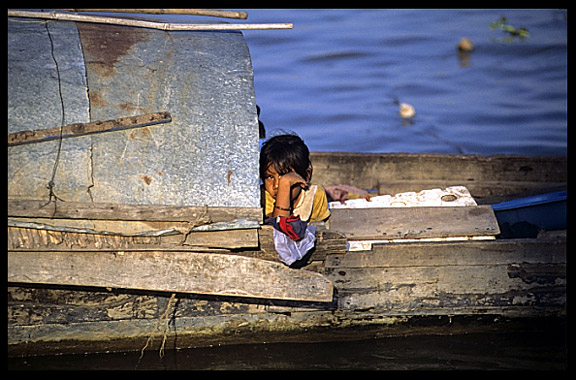 A Cambodian girl is looking from a boat in the Mekong river.