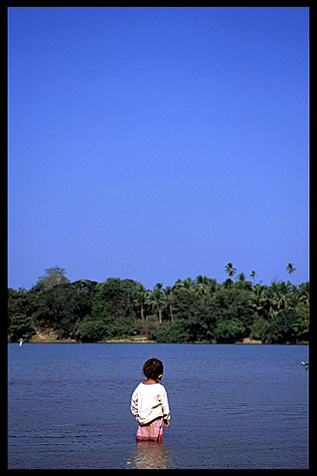 A little girl standing in the Tonle San, Voen Sai, Cambodia