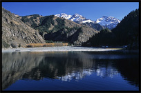 Heaven Pool or Heavenly Lake (Tian Chi) with snow-covered Tian Shan mountains in the distance. Urumqi, Xinjiang, China