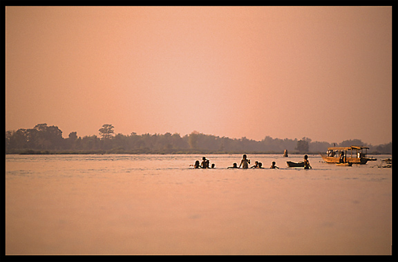 During sunset, kids play in the Mekong River. Si Phan Don, Don Khong, Laos