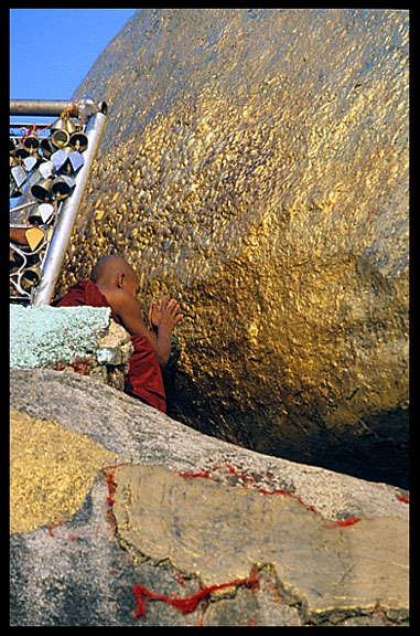 A monk taking his time at the balancing boulder stupa in Kyaiktiyo.