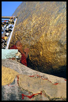 A monk taking his time at the balancing boulder stupa in Kyaiktiyo.