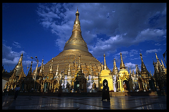 Silhouettes in front of the great golden dome of Shwedagon Paya in Yangon.