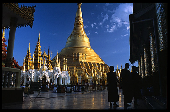 The silhouettes of monks in front of the great golden dome of Shwedagon Paya in Yangon.