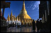 The silhouettes of monks in front of the great golden dome of Shwedagon Paya in Yangon.