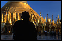 The silhouette of a monk in front of the great golden dome of Shwedagon Paya in Yangon.