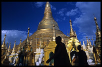 Silhouettes of monks in front of the great golden dome of Shwedagon Paya in Yangon.