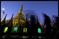 Magical moments at Shwedagon Paya. Silhouettes of devotees at night in front of the golden dome.