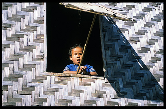In the Intha village of Nanthe, near Nyaungshwe, a yound child is staring out of the window.