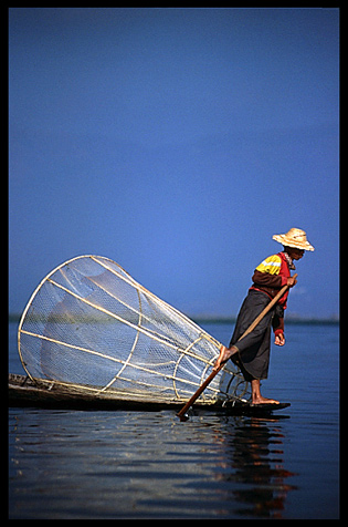 Leg rowing Intha fisherman in sampan on Inle Lake in Shan State.