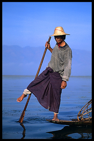 Leg rowing Intha fisherman in sampan on Inle Lake in Shan State.