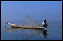 Leg rowing Intha fisherman in sampan on Inle Lake in Shan State.