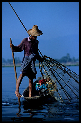 Leg rowing Intha fisherman in sampan on Inle Lake in Shan State.