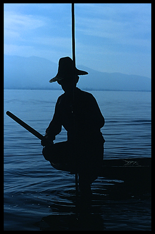 Leg rowing Intha fisherman in sampan on Inle Lake in Shan State.