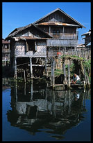 A Burmese man doing the laundry in front of a house on stilts in one of the floating villages in Inle Lake.