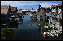 A Burmese woman doing the laundry in front of a house on stilts in one of the floating villages in Inle Lake.
