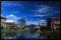 A Burmese woman doing the laundry in front of a house on stilts in one of the floating villages in Inle Lake.