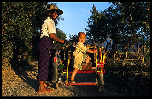 A Burmese man and his child cycling along Inle Lake in Nanthe.