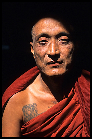 A monks showing his tattoo.