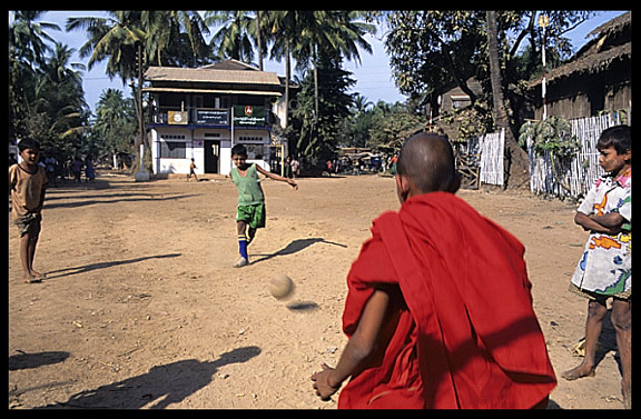 A monk is playing soccer in Twante near Yangon.