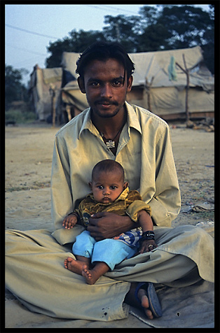 An Afghan refugee with his young child. Taxila, Pakistan