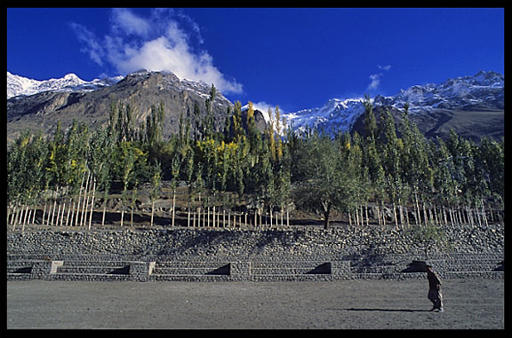 A man is crossing the polo ground. Karimabad, Hunza, Pakistan