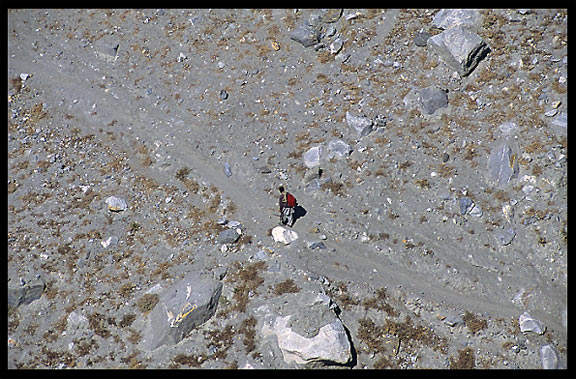 A Hunzakut walking through a water channel. Karimabad, Hunza, Pakistan