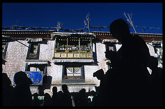 The silhouettes of pilgrims on the Barkhor Kora around the Jokhang.