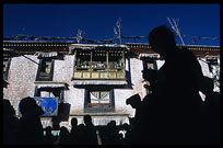 The silhouettes of Tibetan pilgrims on the Barkhor Kora around the Jokhang. Lhasa, Tibet, China