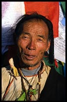 Old Tibetan pilgrim in front of prayer flags. Lhasa, Tibet, China