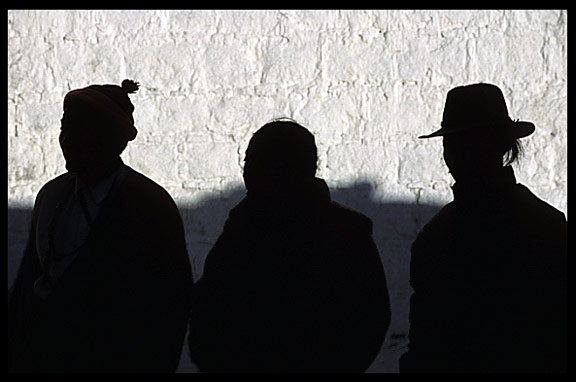 Silhouettes of pilgrims down a narrow alley on the Barkhor Kora.