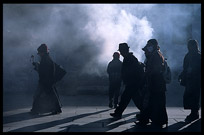 Smoke from the incense burners creates silhouettes of Tibetan pilgrims. Lhasa, Tibet, China