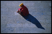 A Tibetan monk is resting on the Barkhor Square. Lhasa, Tibet, China