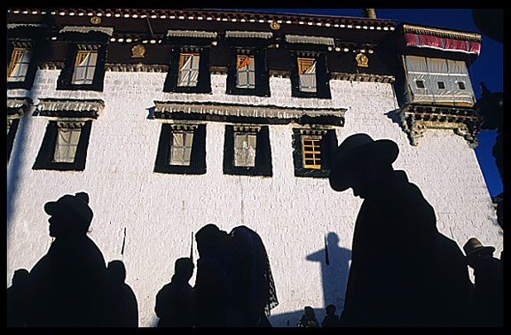The silhouettes of pilgrims on the Barkhor Kora around the Jokhang.