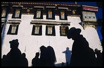 The silhouettes of Tibetan pilgrims on the Barkhor Kora around the Jokhang. Lhasa, Tibet, China