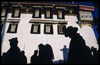 The silhouettes of Tibetan pilgrims on the Barkhor Kora around the Jokhang. Lhasa, Tibet, China