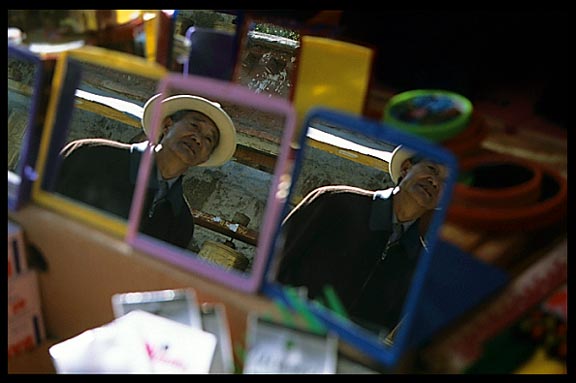 Mirrors in a stall on the Potala Kora reflecting a pilgrim.