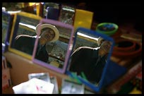 Mirrors in a stall on the Potala Kora reflecting a Tibetan pilgrim. Lhasa, Tibet, China