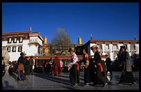 Tibetan pilgrims walking the Barkhor Kora in front of the Jokhang. Lhasa, Tibet, China